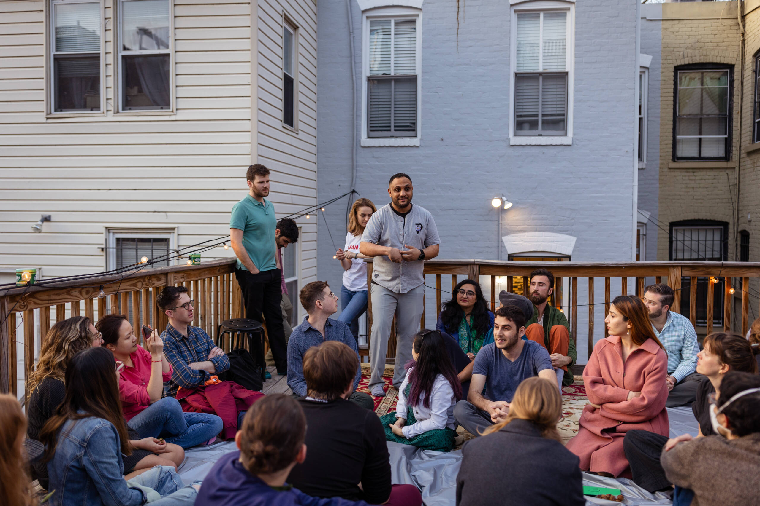 Abrahamic House gathering, people of different ethnicities on an urban back deck